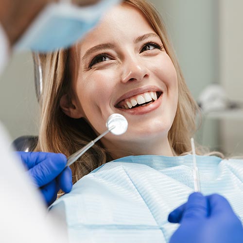 woman smiling at endodontist at dental hygiene treatment